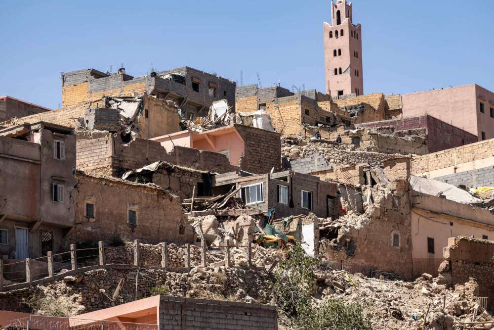 caption: The minaret of a mosque stands behind damaged or destroyed houses following an earthquake in Moulay Brahim, Al-Haouz province, on Sept. 9, 2023. (Fadel Senna/AFP via Getty Images)