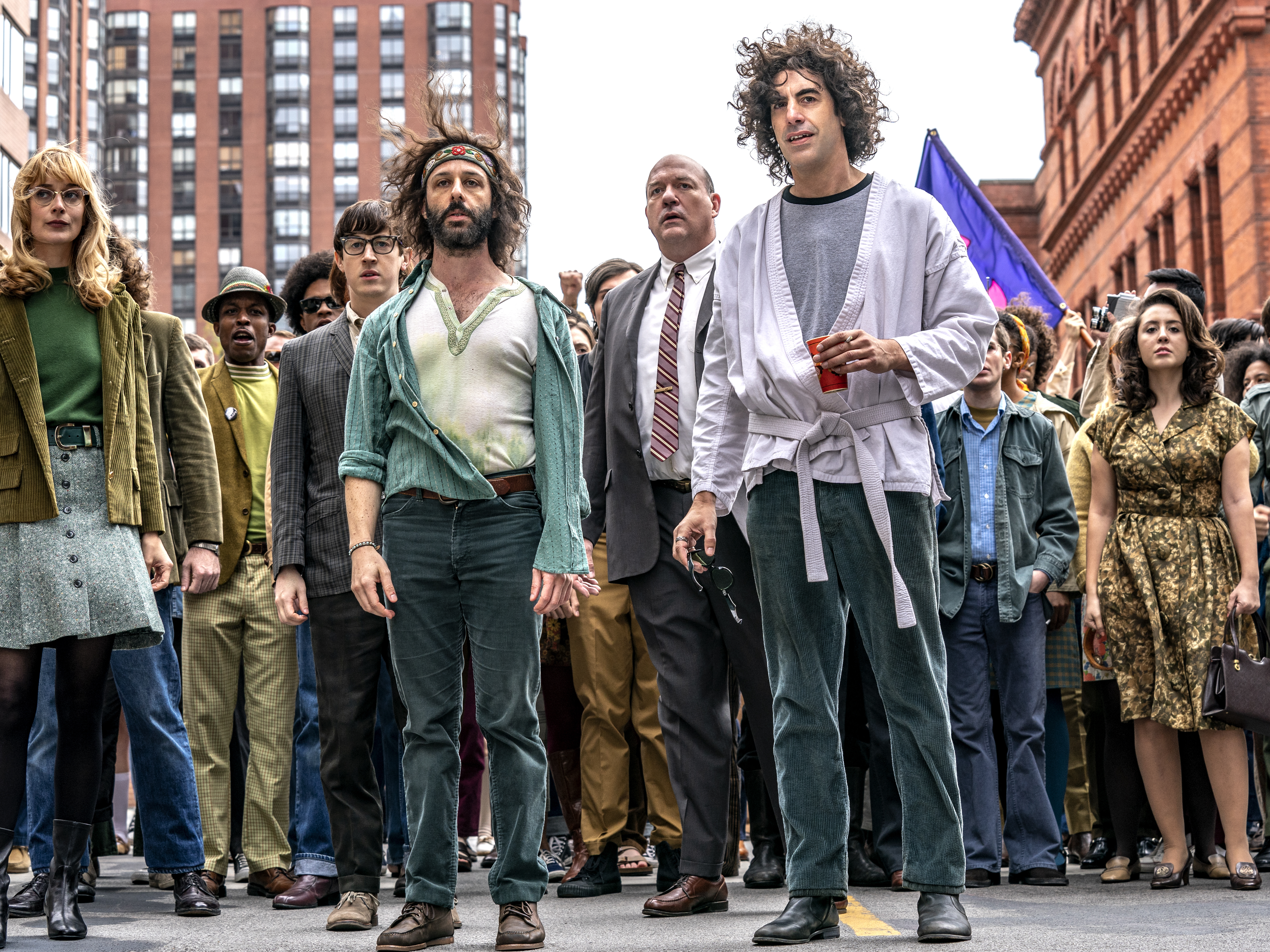 caption: Sacha Baron Cohen, front right, plays Abbie Hoffman in <em>The Trial of the Chicago 7.</em>