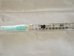 caption: A single-use syringe awaits to be filled with the Moderna COVID-19 vaccine. Moderna has sued rival drugmakers for patent infringement.