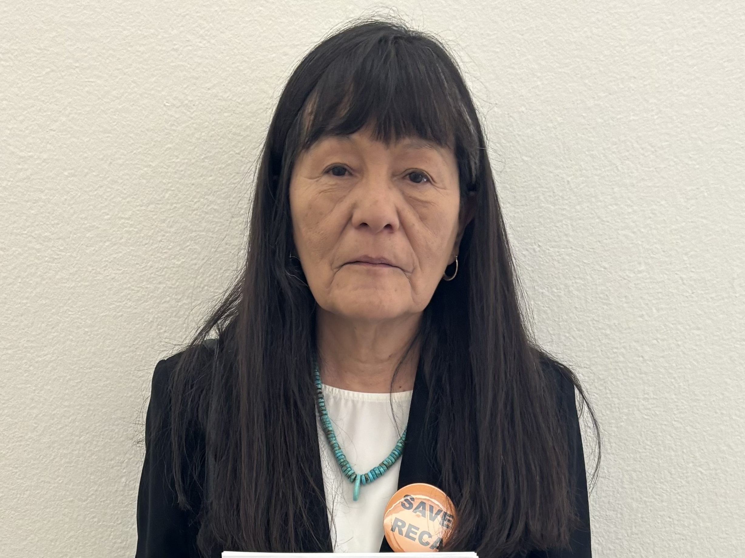caption: Maggie Billiman holds a picture of her late parents, Mary Louis and Howard Billiman. She believes her father died of cancer related to his exposure to nuclear fallout.