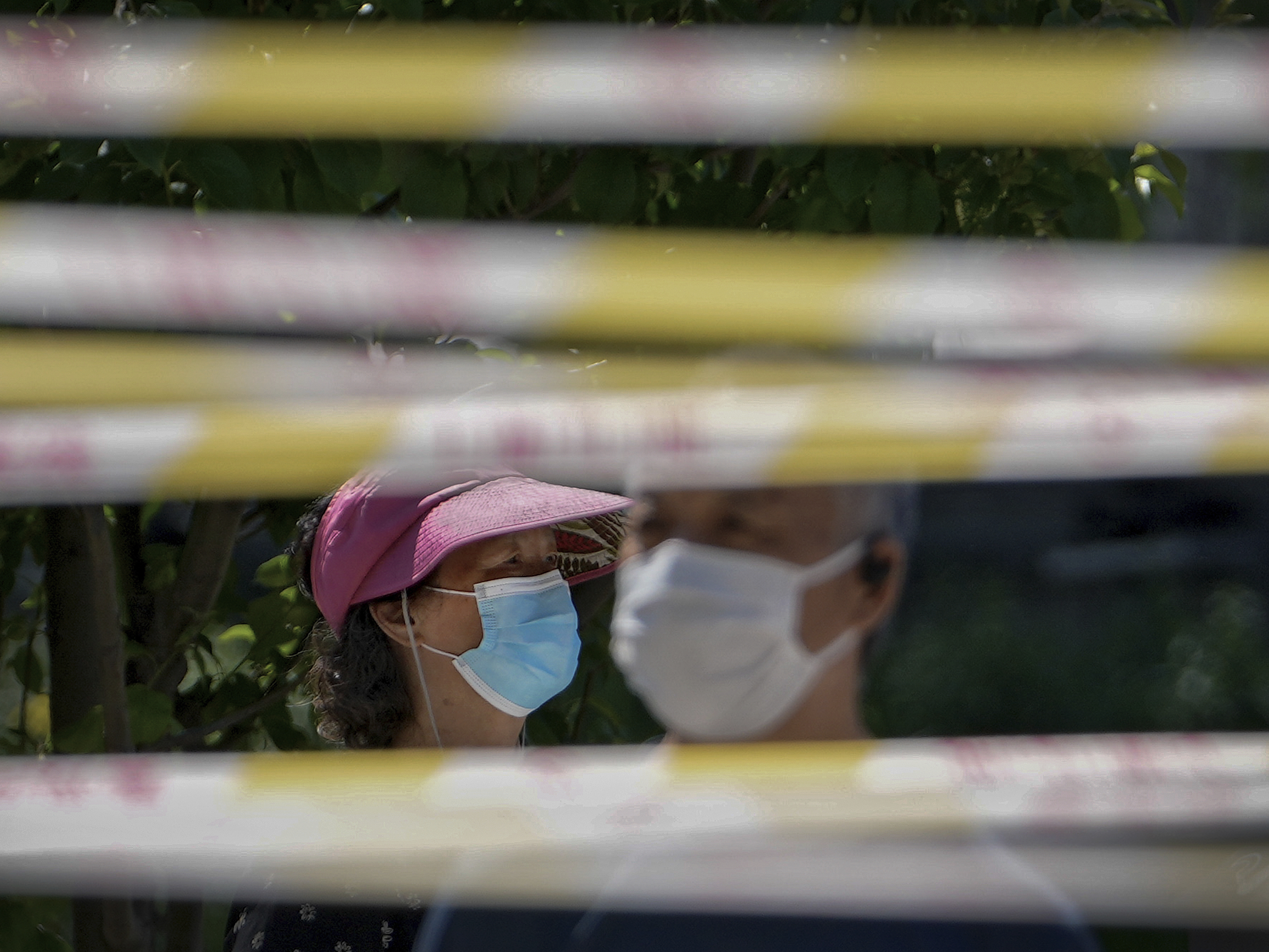 caption: Residents wearing face masks line up behind barricaded tapes for COVID mass testing near a residential area on May 15, 2022, in Beijing. The World Health Organization says it's made an official request to China for information about a potentially worrying spike in respiratory illnesses and clusters of pneumonia in children.