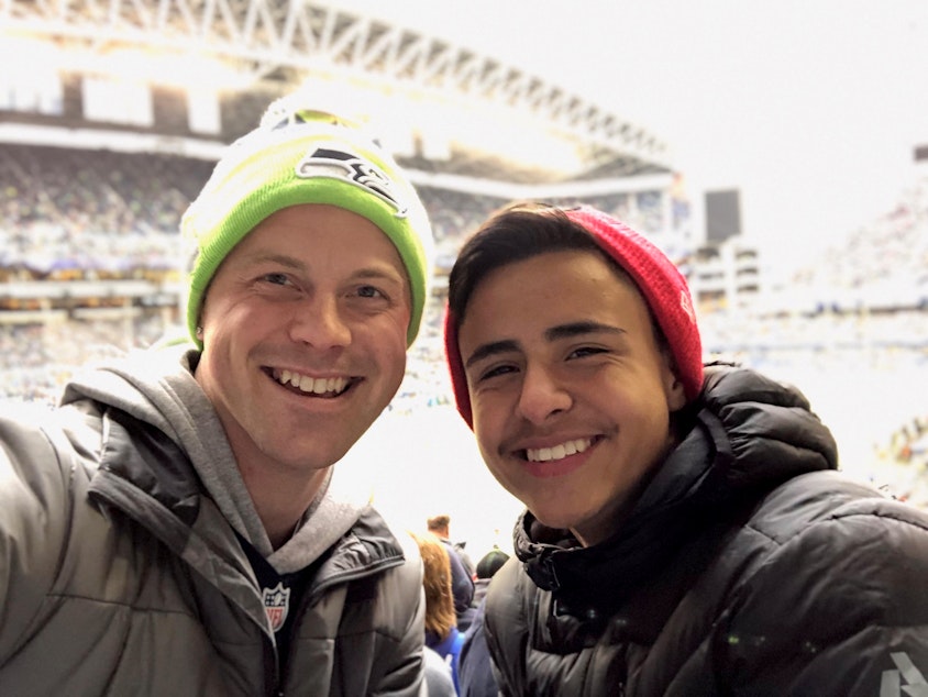 caption: Eriberto Saavedra Felix (right) and his teacher and mentor, Reid Sunblad, attend a Seahawks game — even though Eriberto is a 49ers fan.