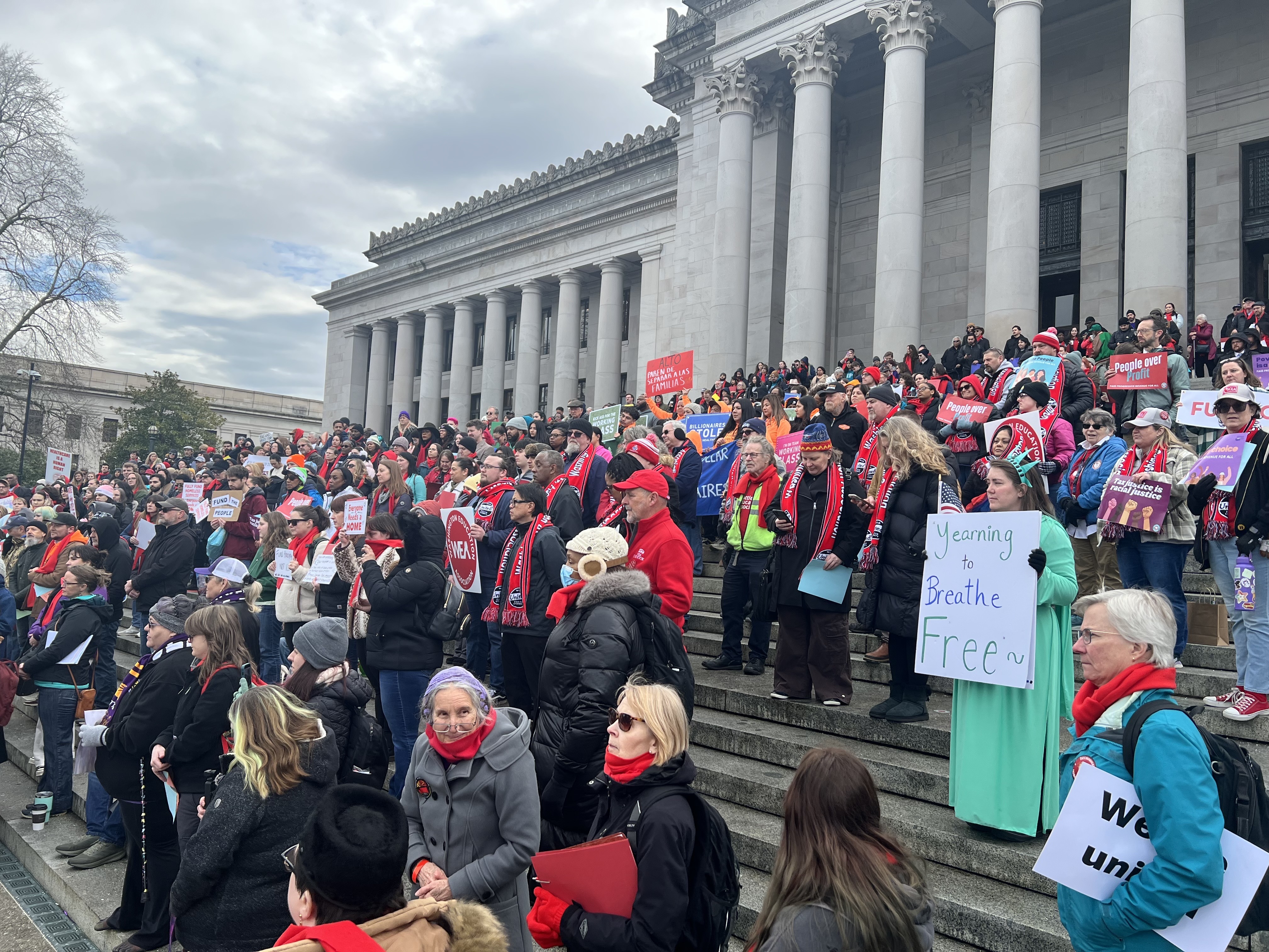 caption: Tax reform demonstrators gather on the Capitol steps in Olympia on Jan. 26, 2026.