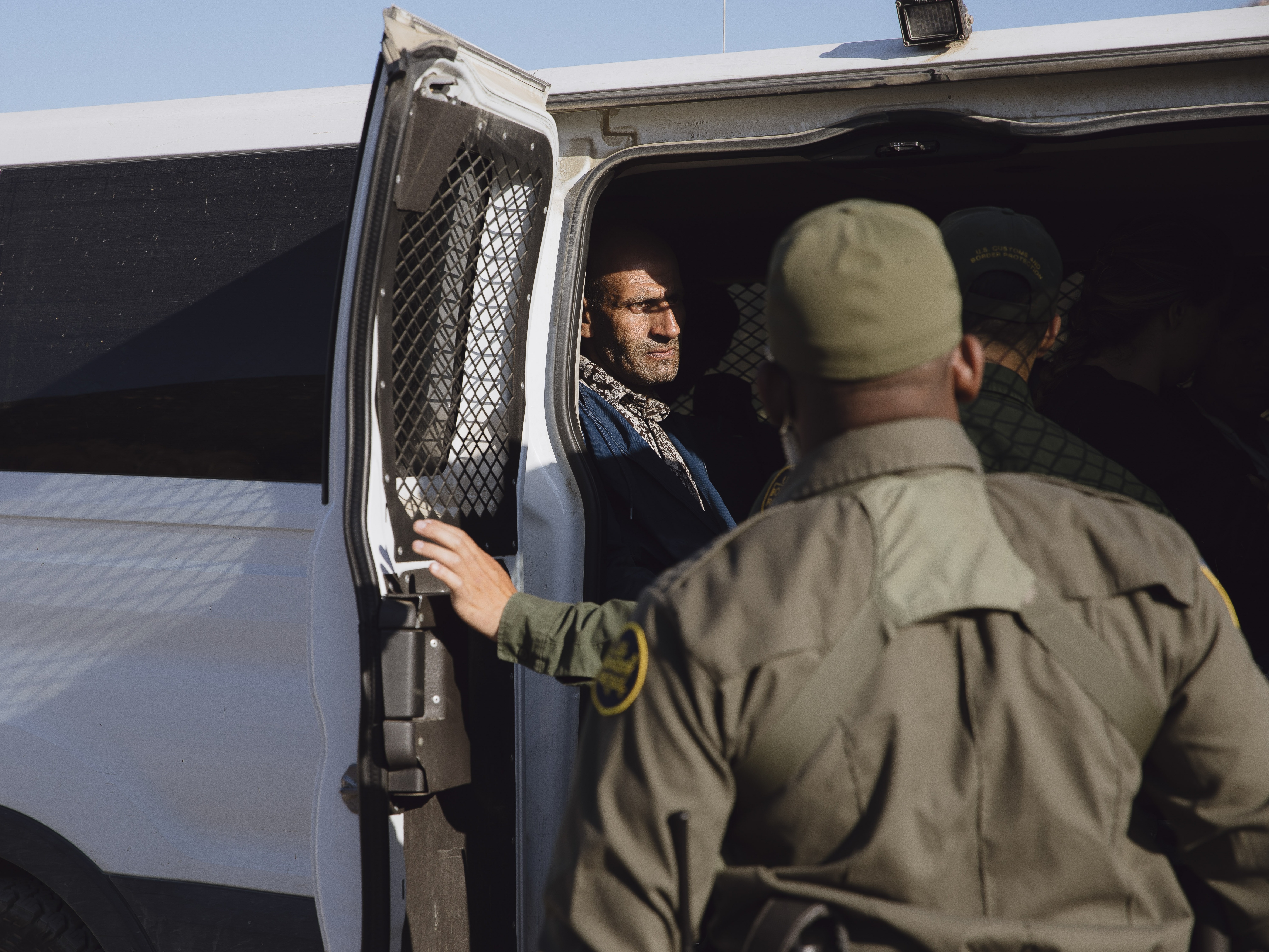 caption: Border patrol agents pick up migrants waiting to be processed in Dulzara, California on June 25, 2024.