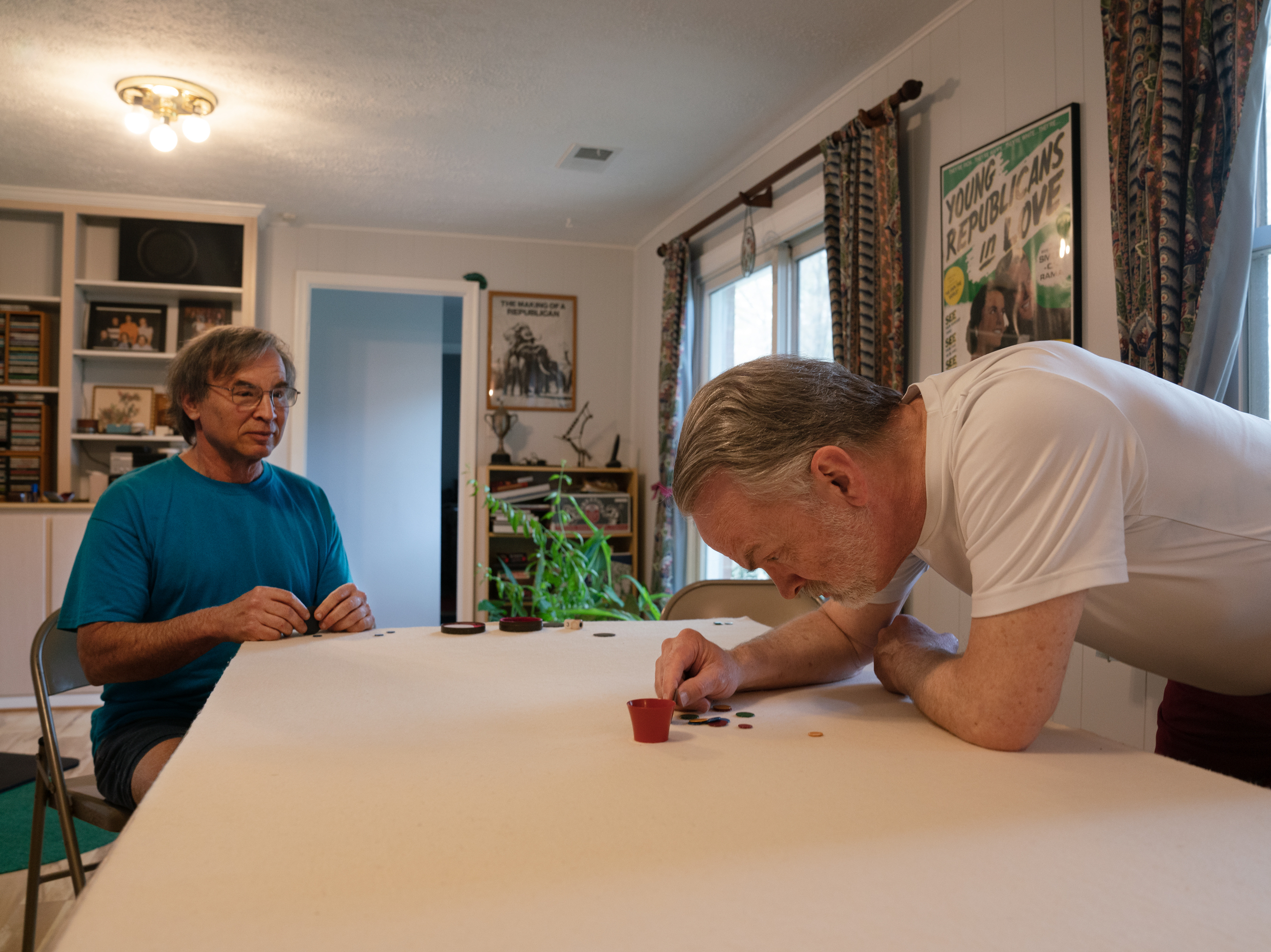 caption: Larry Kahn (left) and Dave Lockwood, practice tiddlywinks. The game has a startlingly simple premise for a game that draws an academic fandom.