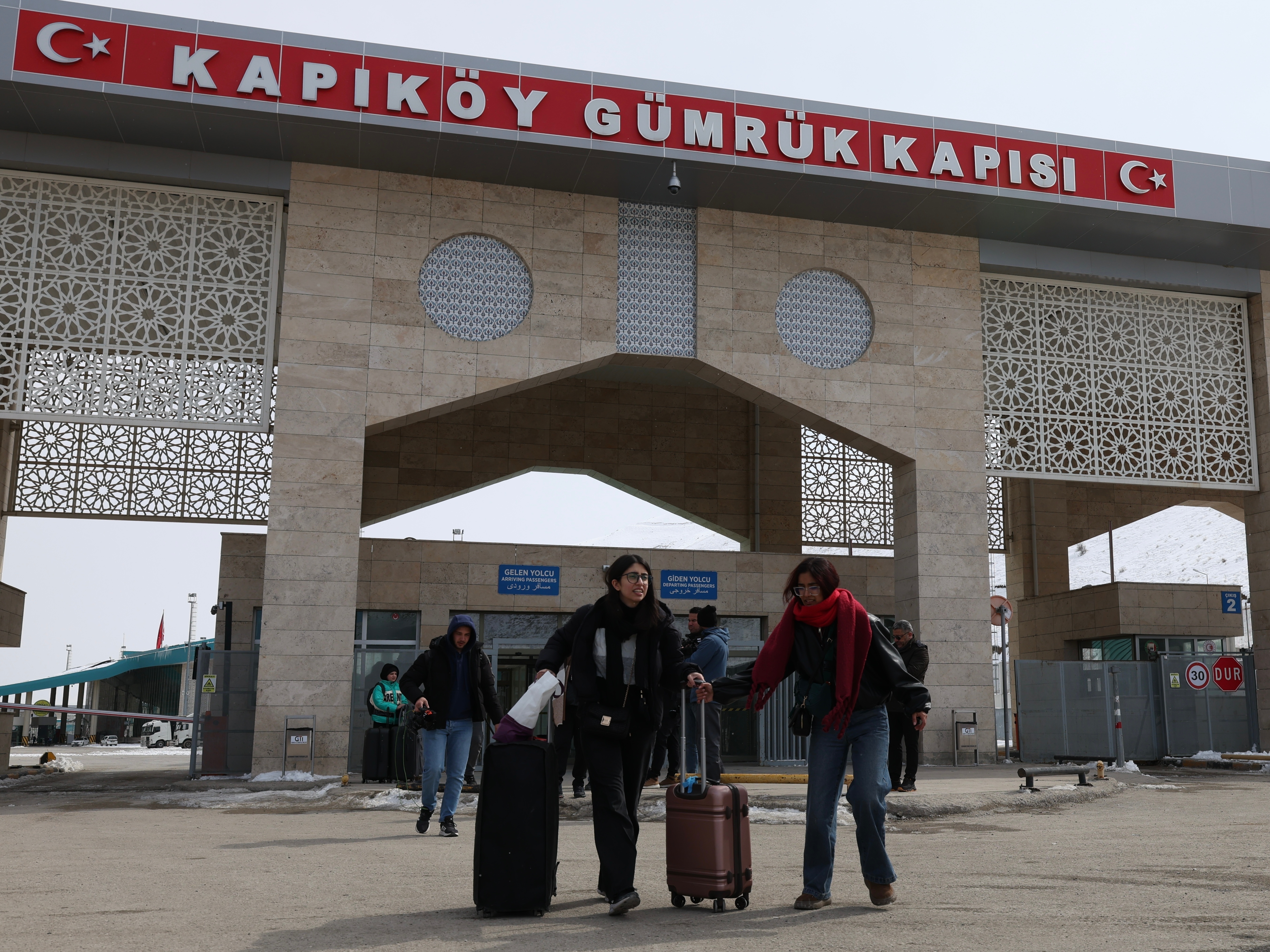 caption: People at the Kapikoy border crossing between Turkey and Iran, in eastern Van province, Turkey, March 2.