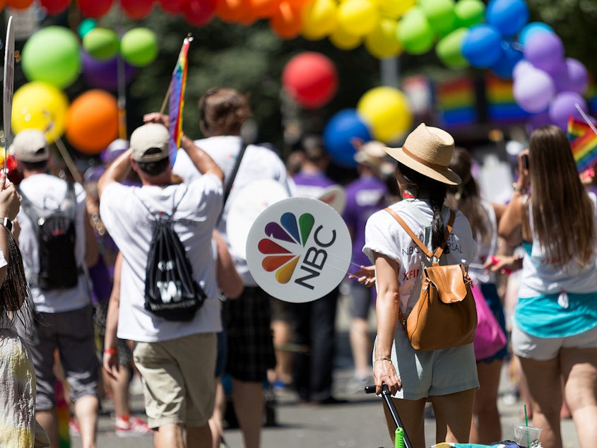 caption: The OUT@Comcast team members and friends marching in the 2017 Seattle Pride Parade, by Stephen Wong.