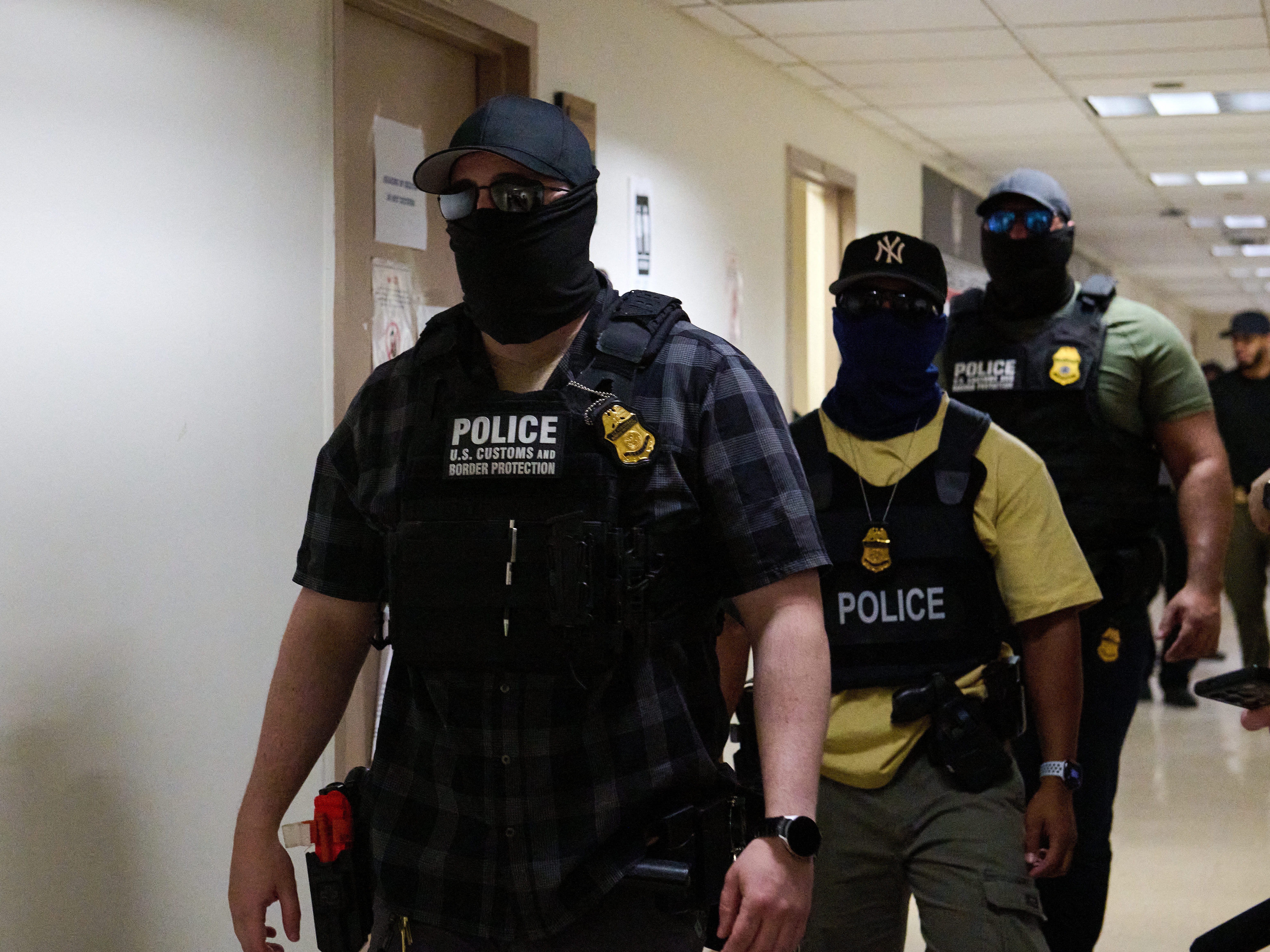 caption: Federal agents working for U.S. Immigration and Customs Enforcement (ICE) detain immigrants and asylum seekers reporting for immigration court proceedings at the Jacob K. Javits Federal Building's U.S. Immigration Court in New York, New York, Thursday. Some Democratic lawmakers are proposing legislation that would prohibit federal agents from wearing masks.