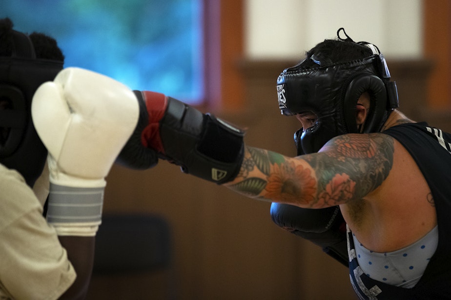 caption: Nikkita Oliver, right, boxes with Durojaiye Heru during instructor Darnell Hill’s boxing class, on Wednesday, July 17, 2024, at Washington Hall in Seattle.