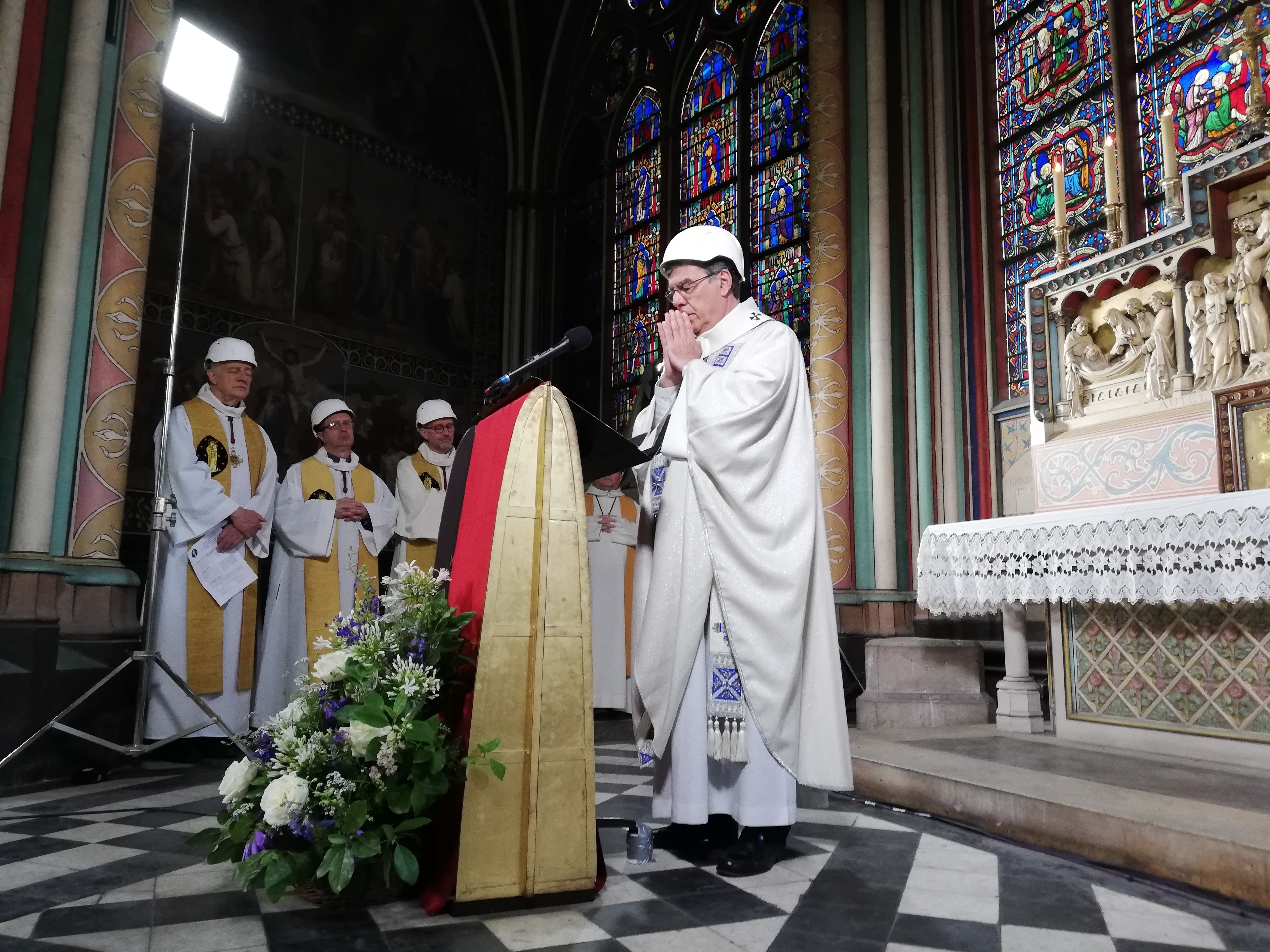 caption: A small group in hard hats gathered on Saturday for Mass in Paris' Notre Dame cathedral. It was the first Mass since a fire devastated the church in April.