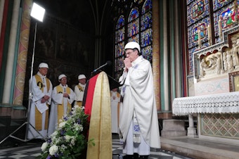 caption: A small group in hard hats gathered on Saturday for Mass in Paris' Notre Dame cathedral. It was the first Mass since a fire devastated the church in April.