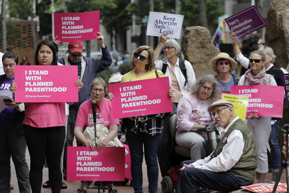 caption: FILE - In this July 10, 2018 file photo, protesters hold signs supporting Planned Parenthood in Seattle, as they demonstrate against President Donald Trump and his choice of federal appeals Judge Brett Kavanaugh as his second nominee to the Supreme Court. 