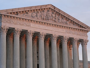caption: The setting sun illuminates the Supreme Court building in Washington on Jan. 10.