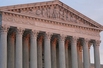 caption: The setting sun illuminates the Supreme Court building in Washington on Jan. 10.
