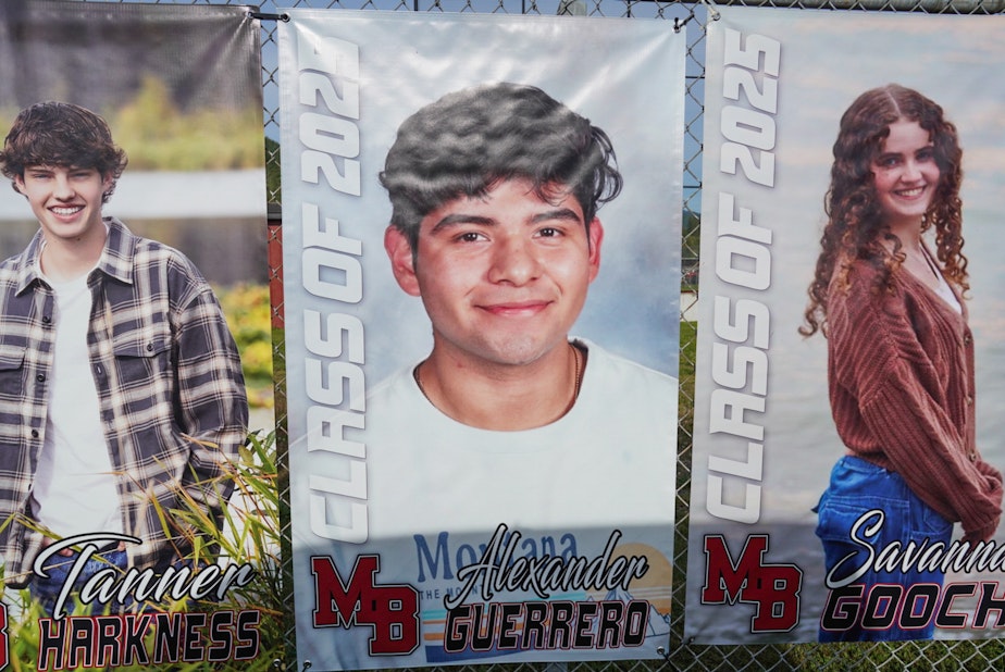 caption: Portraits of the Mt. Baker High School graduating class of 2025 are hung along a fence, including a yearbook photo of Alex Guerrero Villatoro.