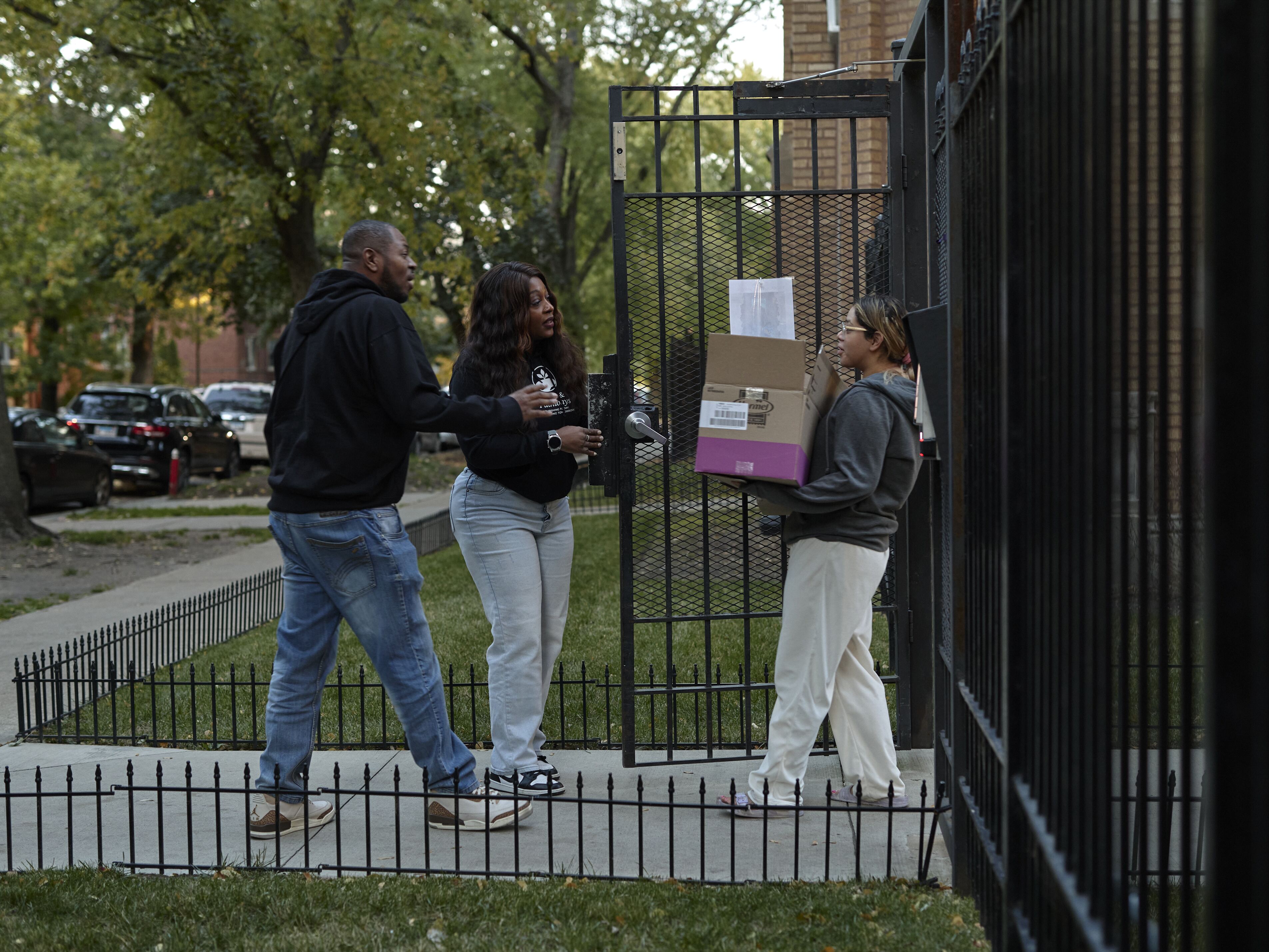 caption: Alicia Spradley (left) and her husband purchased groceries for a young SNAP recipient who may run out of benefits in Chicago on Oct. 30.