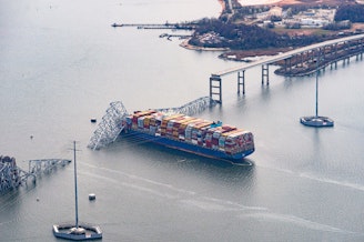 caption: The Dali container vessel after striking the Francis Scott Key Bridge that collapsed into the Patapsco River in Baltimore, on Tuesday. The Port of Baltimore, which has the highest volume of auto imports in the U.S., is now temporarily closed.