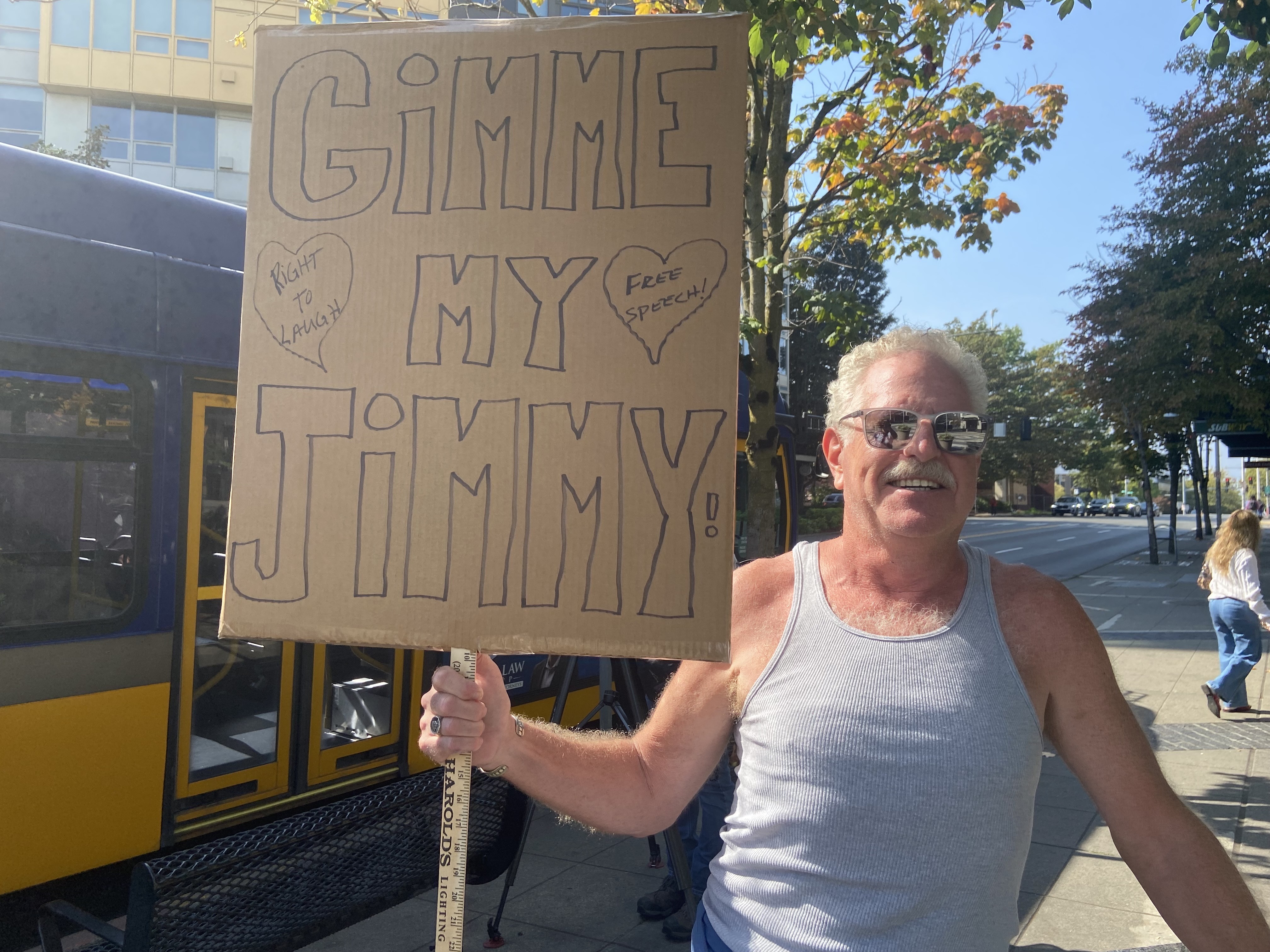 caption: Chris Kevorkian stands outside KOMO Plaza in support of comedian Jimmy Kimmel on Sept. 23, 2025. 
