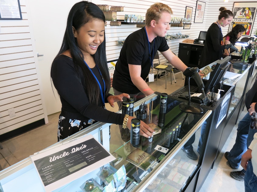 caption: Employees at Ike's Pot Shop in Seattle's Central District sell marijuana products on their opening day, Sept. 30, 2014.