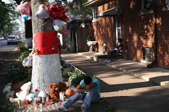 CHICAGO, IL - JULY 06: A teenage boy grieves next to a makeshift memorial at the site where Ashley Hardmon was shot and killed on July 4, 2013 in Chicago, Illinois. (Photo by Scott Olson/Getty Images)