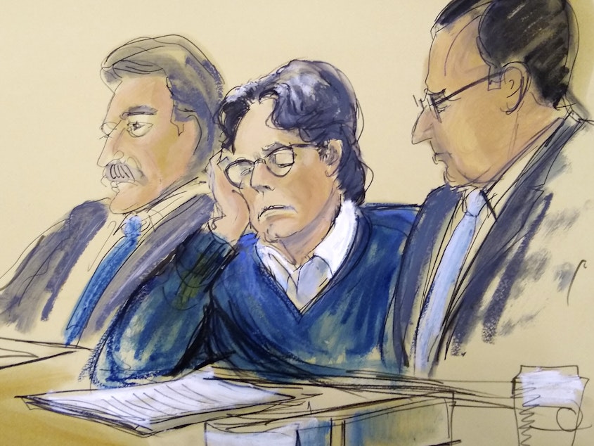 caption: Keith Raniere was sentenced on Tuesday to 120 years in prison for his role as ringleader of the NXIVM cult, where he sexually abused several young women. In this June 2019 courtroom artist's sketch, Raniere, center, sits with his attorneys during closing arguments at federal court in Brooklyn, N.Y.