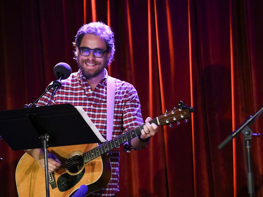 caption: House musician Jonathan Coulton leads a parody game on <em>Ask Me Another</em> at the Bell House in Brooklyn, New York.