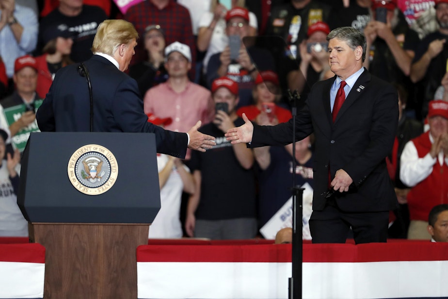 caption: President Donald Trump shakes hands with Fox News Channel's Sean Hannity, right, during a campaign rally Monday, Nov. 5, 2018, in Cape Girardeau, Mo. (Jeff Roberson/AP)