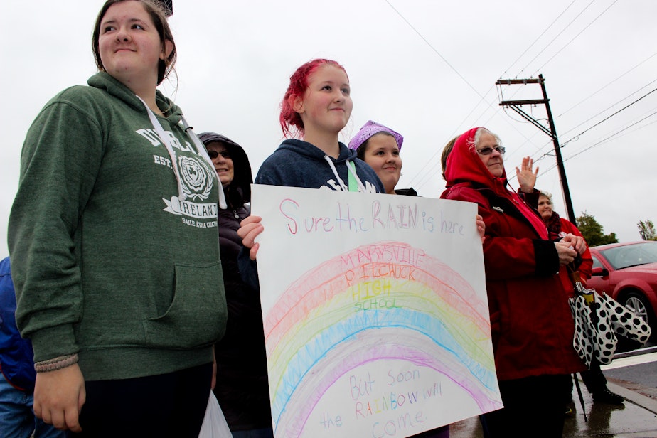 caption: Mary Key, 12, holds a sign she made with her sisters, Esther, 12 (a twin), and Eleanor, 14. The Keys, who are homeschooled, also made a sign for victims of the nearby Oso landslide.
