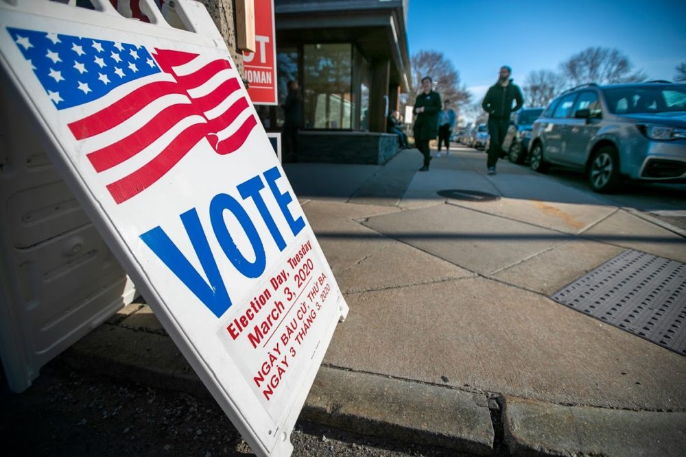 caption: Voters filing in and out at the Allston branch of the Boston Public Library. (Jesse Costa/WBUR)