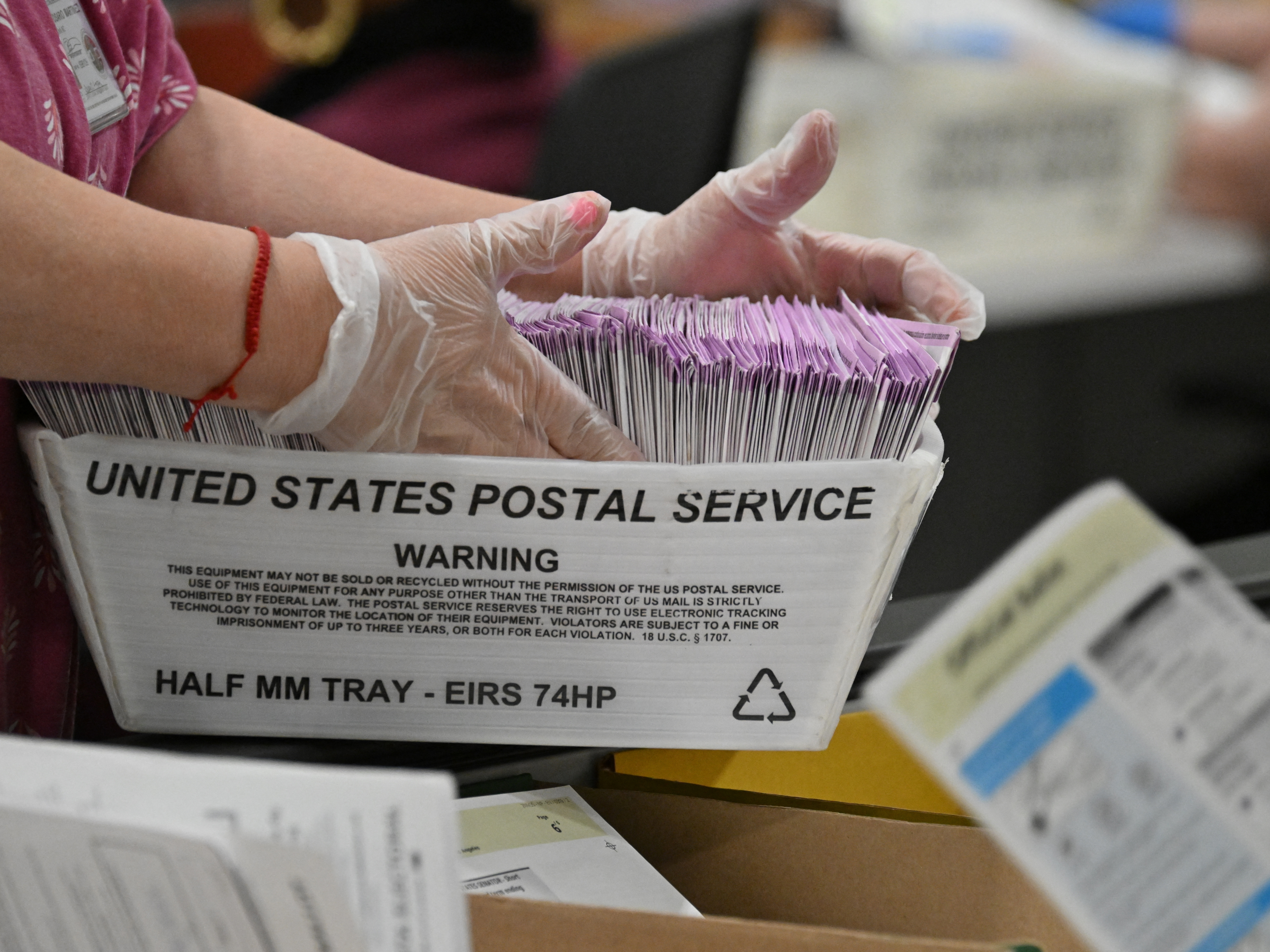 caption: In this file photo, election workers prepare mail-in ballots for tallying at the Los Angeles County Ballot Processing Center on the eve of Election Day, Nov. 4, 2024, in City of Industry, Calif.