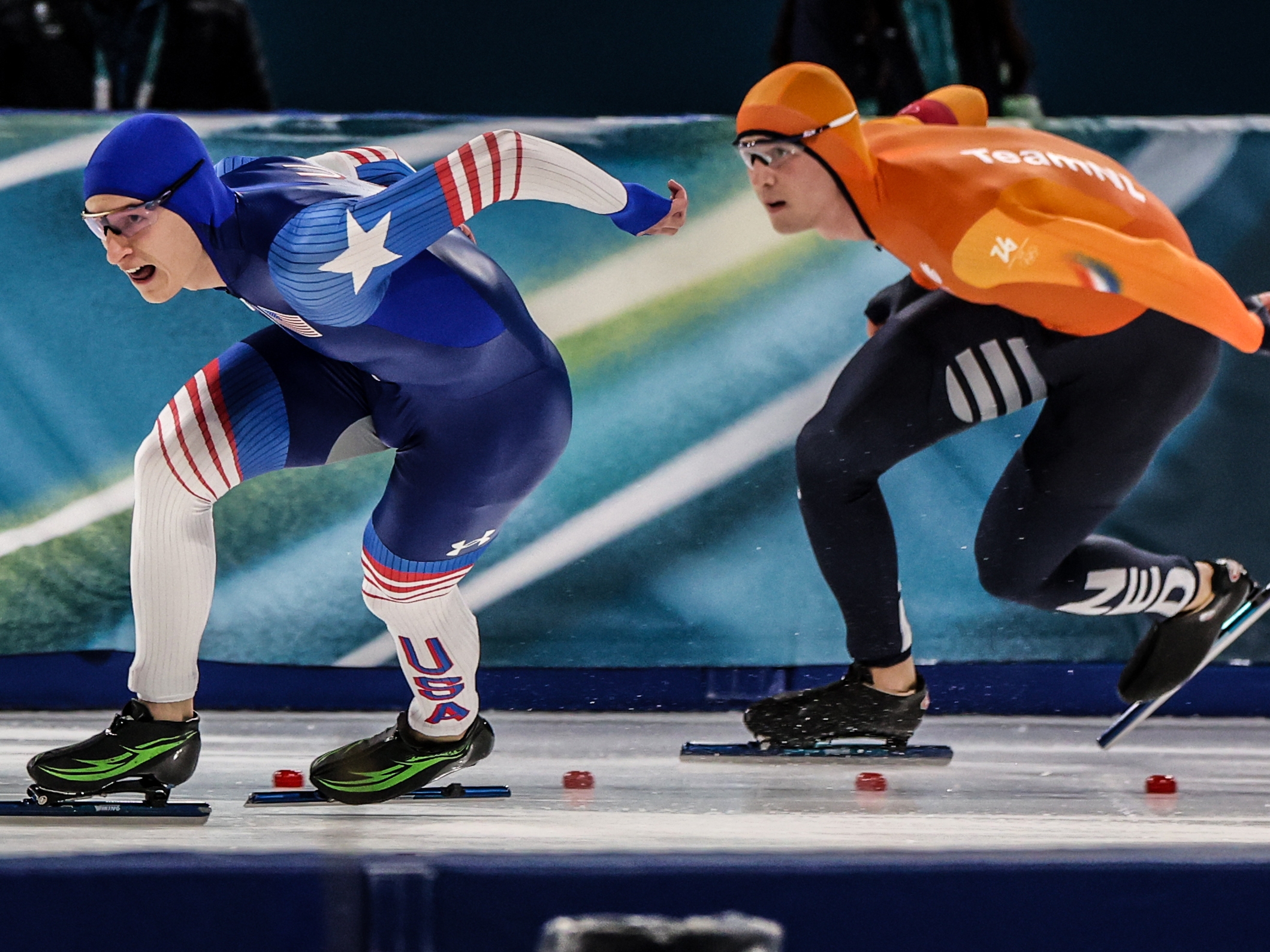 caption: Milan, Italy, Saturday, February 14, 2026 - US skater Jordan Stolz, right, and Netherlands skater Jenning de Boo race in the first lap of the Men's 500 final at Milano Speed Skate Stadium.