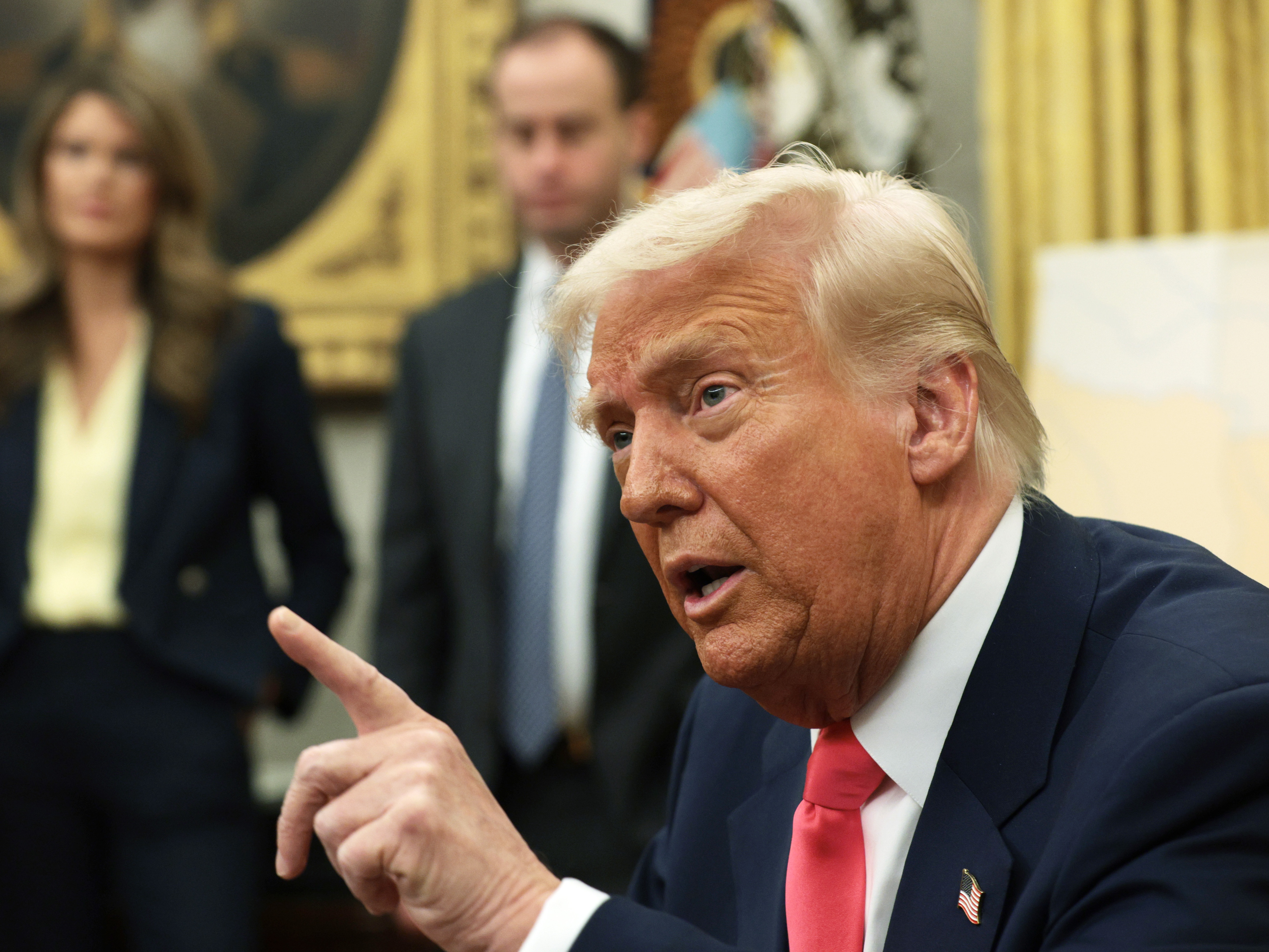 caption: President Trump speaks after signing executive orders in the Oval Office in March 2025, including terminating the security clearances of those who work at the law firm Perkins Coie.