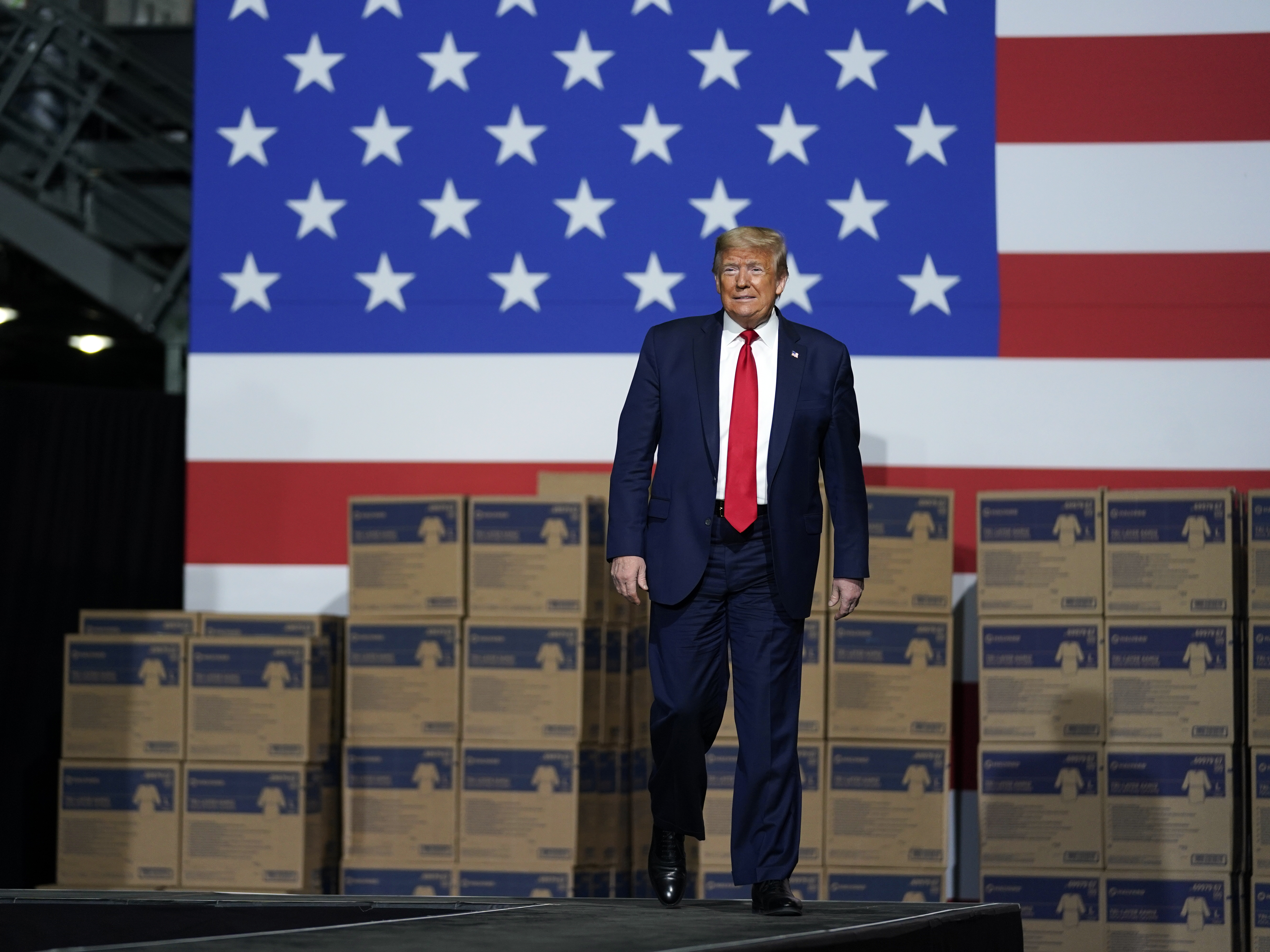 caption: President Trump announced the new role for the Development Finance Corp. in May while touring Owens & Minor Inc., a medical supply company in Allentown, Pa.