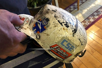 caption: Retired coal miner John Robinson, who suffers from black lung disease, displays his mining helmet at his home in Coeburn, Va., in 2019.