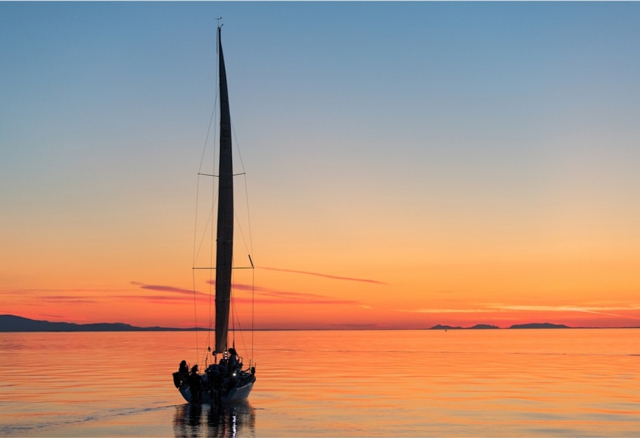 caption: Sail Like a Girl heads off into the sunset.