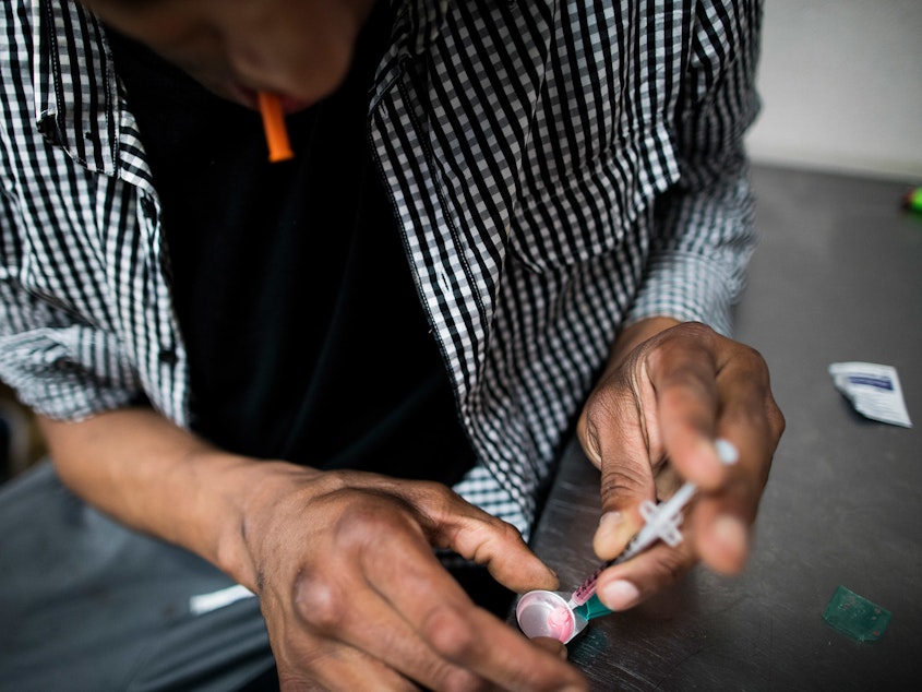 caption: A drug user prepares to inject himself with heroin inside VANDU's supervised injection room in Vancouver, Canada. Similar sites to the ones implemented in New York have proven successful in Canada.