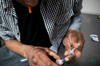 caption: A drug user prepares to inject himself with heroin inside VANDU's supervised injection room in Vancouver, Canada. Similar sites to the ones implemented in New York have proven successful in Canada.