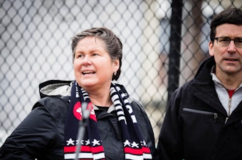 caption: Washington Democratic Party Chair Tina Podlowdowski at the 2018 Seattle Women's March, with Attorney General Bob Ferguson. 
