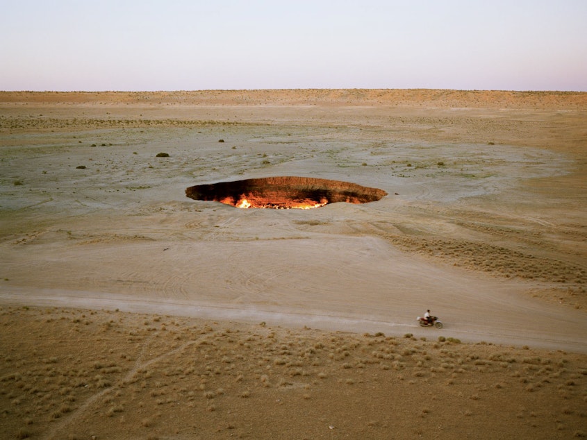 caption: The "Door to Hell." In 1971, Soviet geologists were drilling in the Turkmen desert when the land gave way beneath them, leaving a 70-meter-wide, noxious gas–emitting crater. They ignited the gas to try to burn off the excess, but the crater has been ablaze ever since. Darvaza, Turkmenistan, 2012.