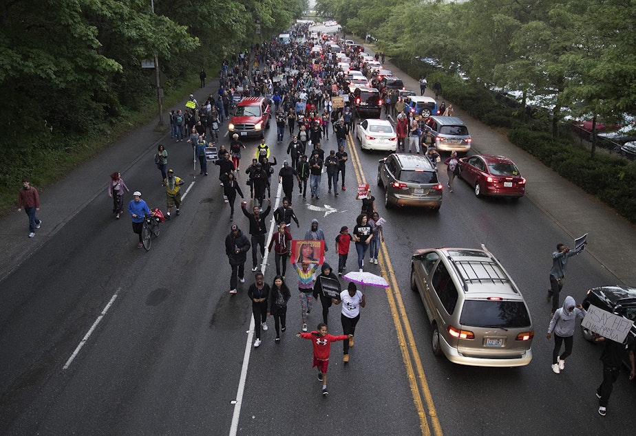 caption: A large crowd marches on Montlake Blvd. after a vigil honoring Charleena Lyles was held at Solid Ground Brettler Family Place on Tuesday, June 19, 2017, in Seattle, Washington. Tap on the image for more photos.