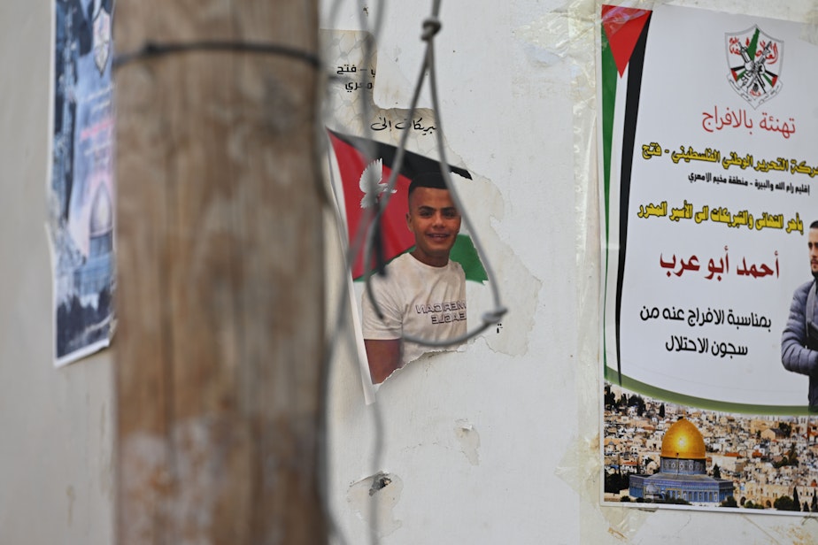 caption: Posters hang on building walls in Ramallah in the West Bank, Oct. 31, 2023.