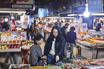 caption: Ivy Chen (left) and Clarissa Wei browse Shuixian Gong Market in Tainan, Taiwan, in January.