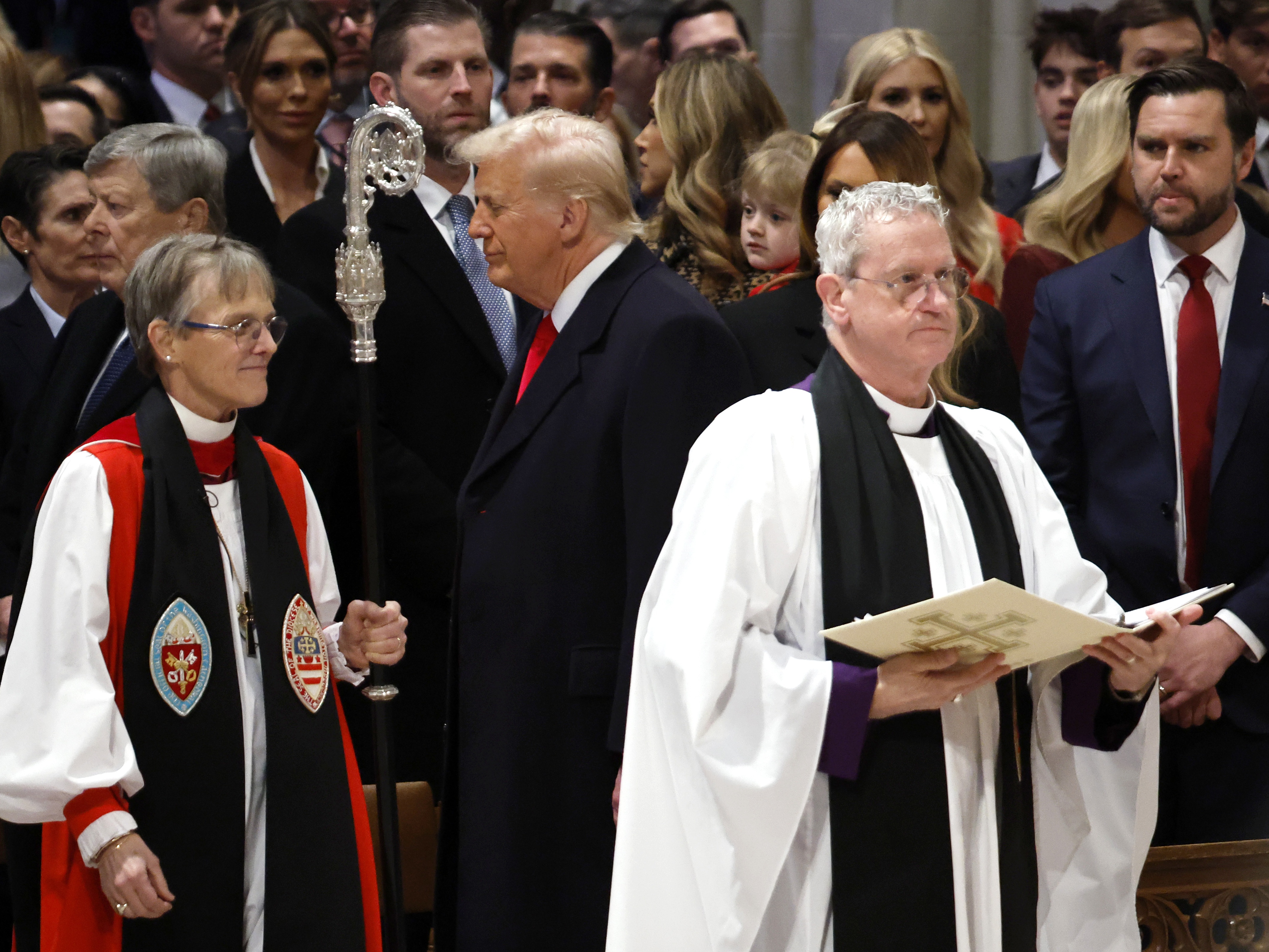 caption: Bishop Mariann Edgar Budde arrives as President Donald Trump and Vice President J.D. Vance look on during the Service of Prayer for the Nation Prayer Service at Washington National Cathedral on Tuesday.