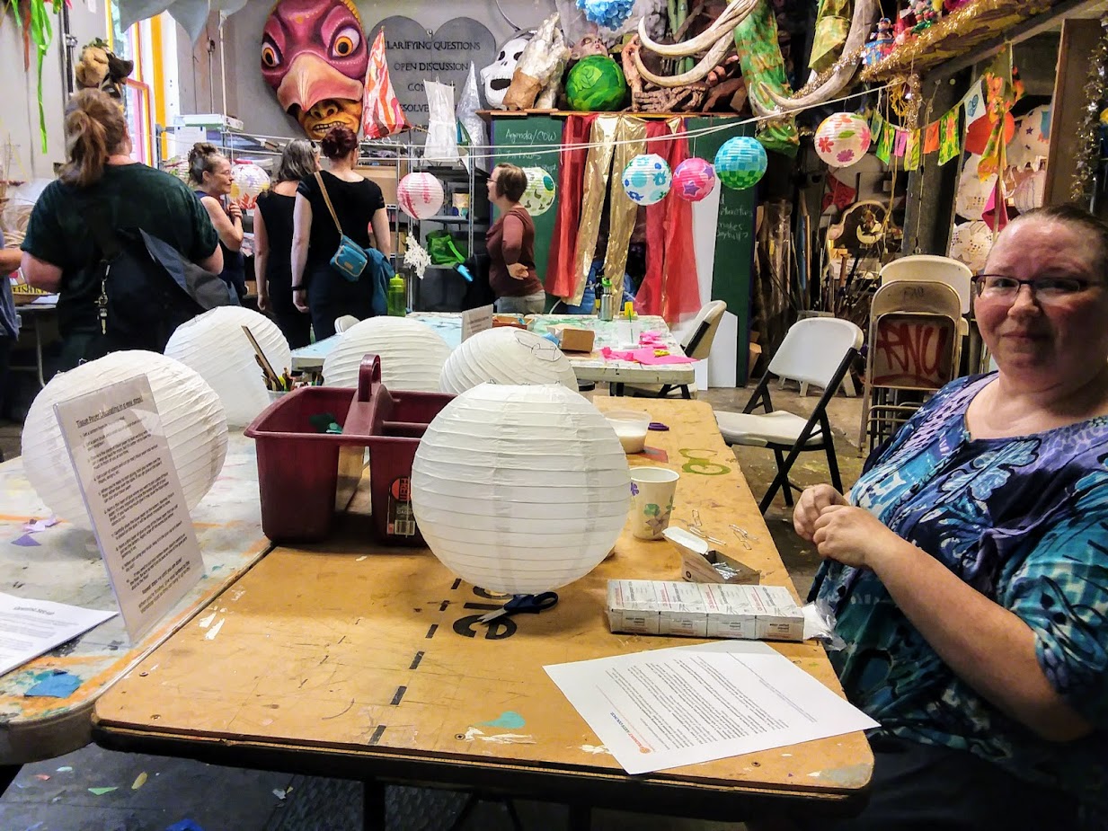 caption: Mimi Noyes, a volunteer instructor, decorates a lantern for the Luminata parade at Green Lake next Thursday.