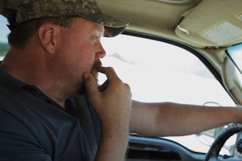 caption: Bob DeYoung drives through the remains of the Oso landslide