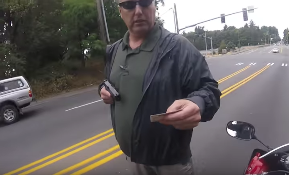 caption: A screenshot from a YouTube video showing King County detective Richard Rowe pulling a gun on a motorcyclist during a traffic stop. He was suspended for five days. 