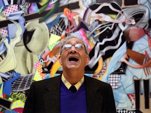 caption: Frank Stella with one of his works at the Royal Academy's Summer Exhibition in London in 2000.