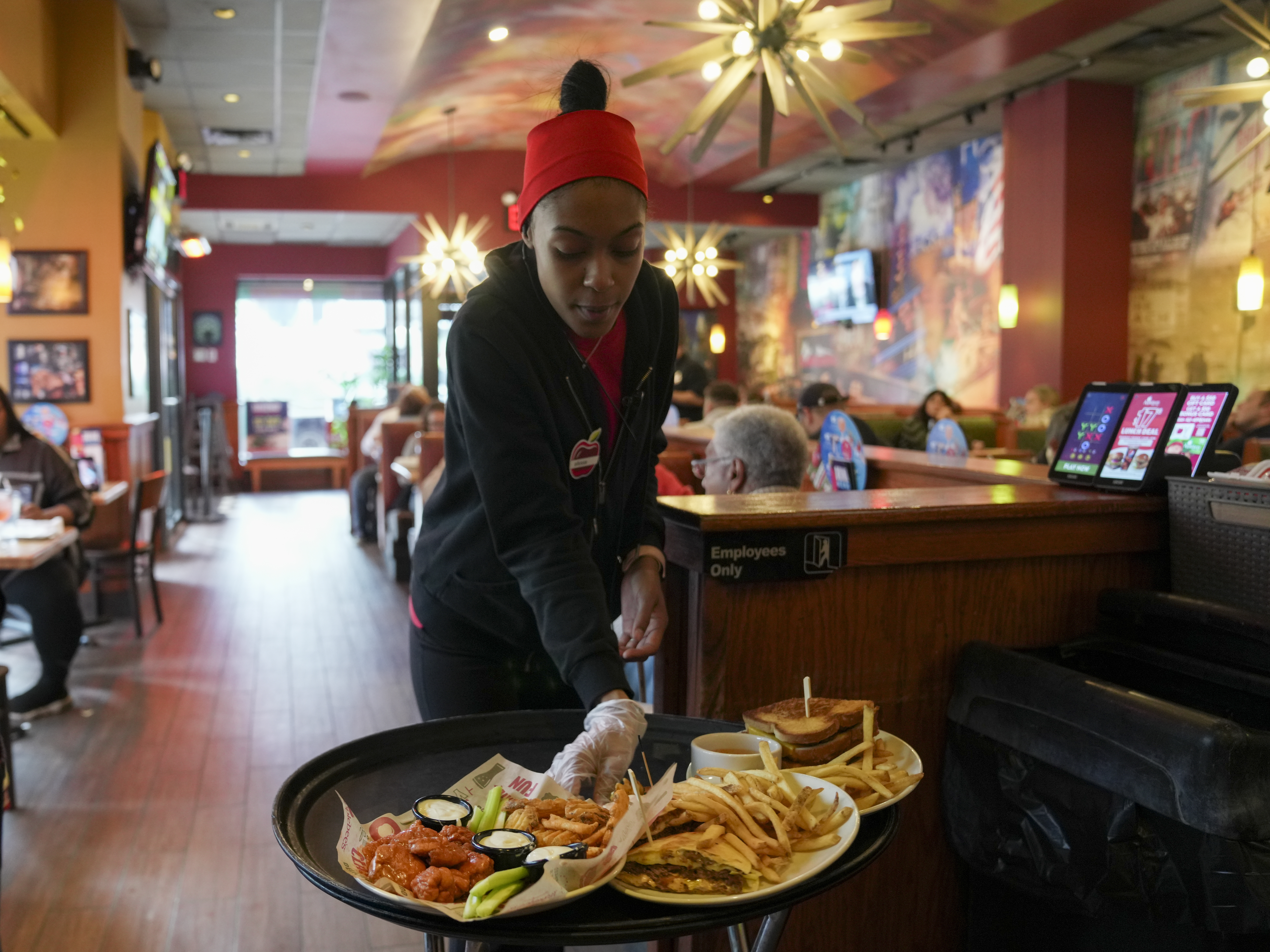 caption: A server delivers food to a table at the world's largest Applebee's in New York City's Times Square.