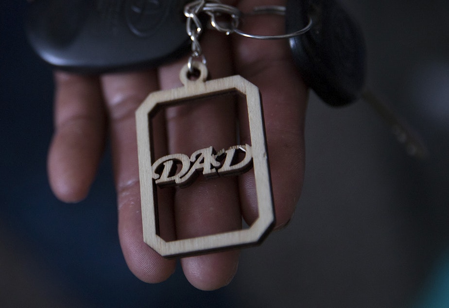 caption: Raul holds a keychain, a gift from his daughter, at his apartment. “When you lose everything… you lose fear too,” he says in a thin voice.