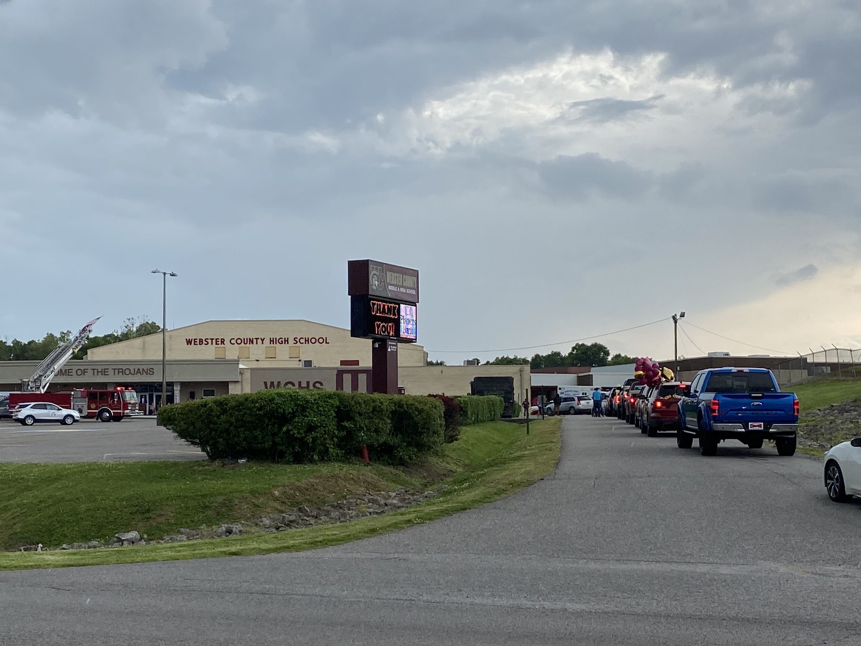 caption: Seniors line up in cars with their families in the main drive of Webster County High School in Dixon, Ky., waiting to pick up their diplomas outside of the school one at a time. Like almost all schools across the U.S., county high school officials had to adapt this year's graduation ceremony because of the COVID-19 pandemic.